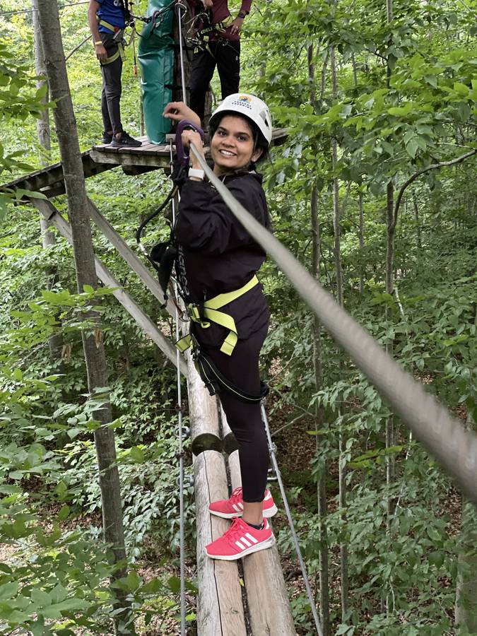 Feny smiling on a high ropes course in the forest