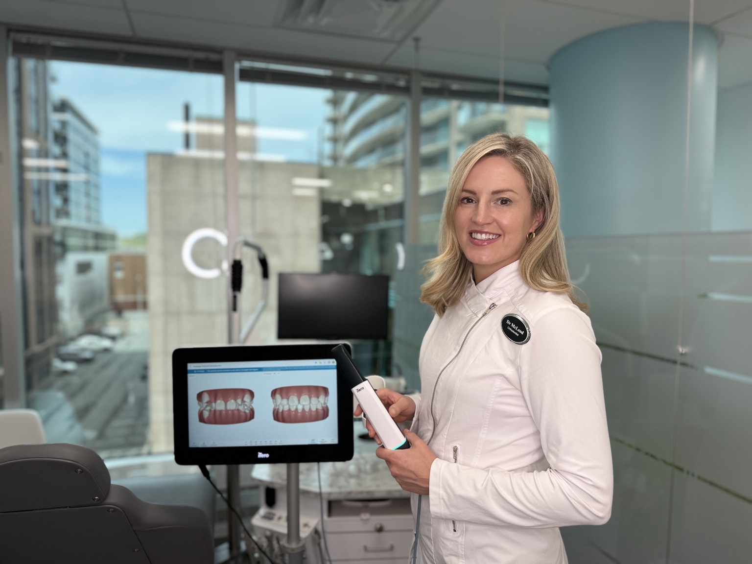 Dr. Catherine McLeod holding the iTero digital scanner, with a bite scan on screen