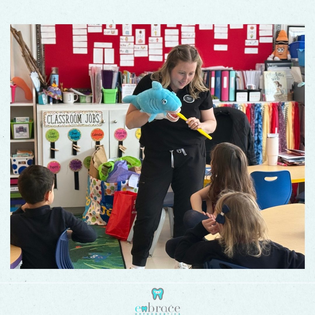 An Embrace Orthodontics team member showing Halifax students how to brush with Sharkie the shark